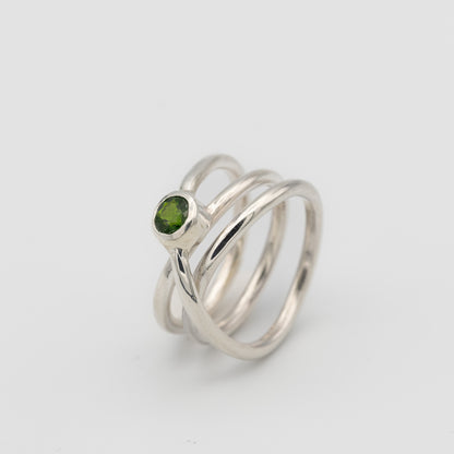 silver handmade ring in a shape of an orbit with a single gemstone set. now single silver wire wrapped and creating coils. 