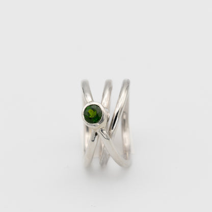 silver handmade ring in a shape of an orbit with a single gemstone set. now single silver wire wrapped and creating coils. 