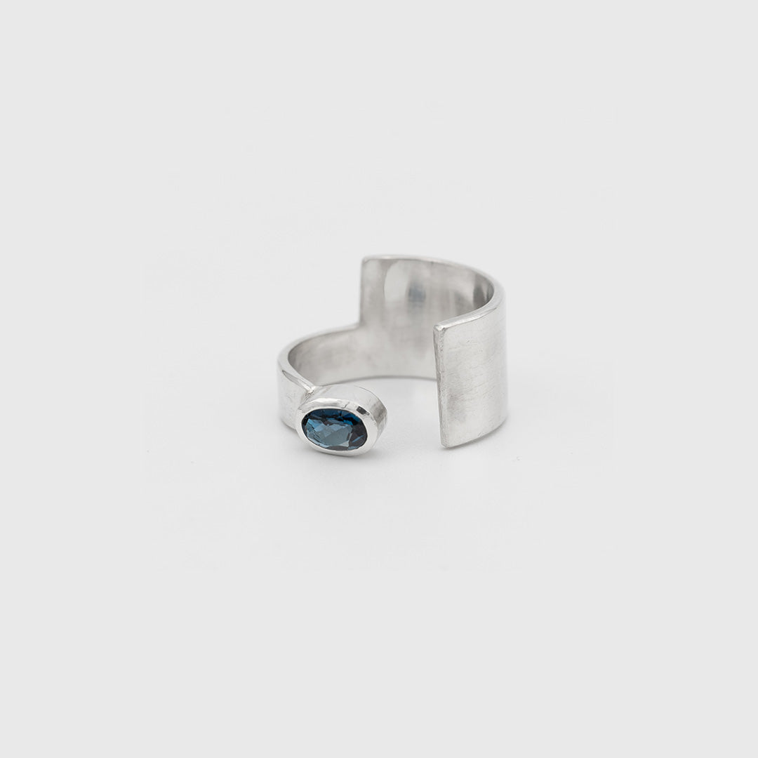 Silver ring with a blue gemstone on a white background