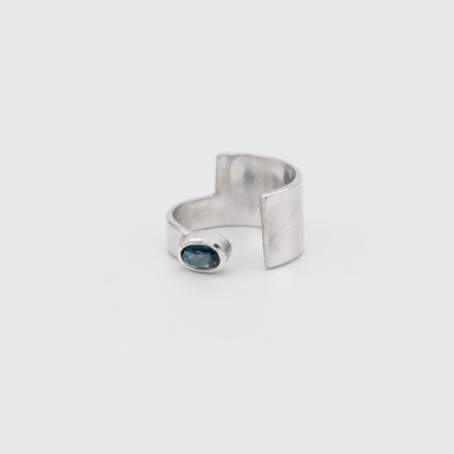 Silver ring with a blue gemstone on a white background