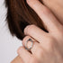 Close-up of a hand wearing a silver ring with a minimalistic design.