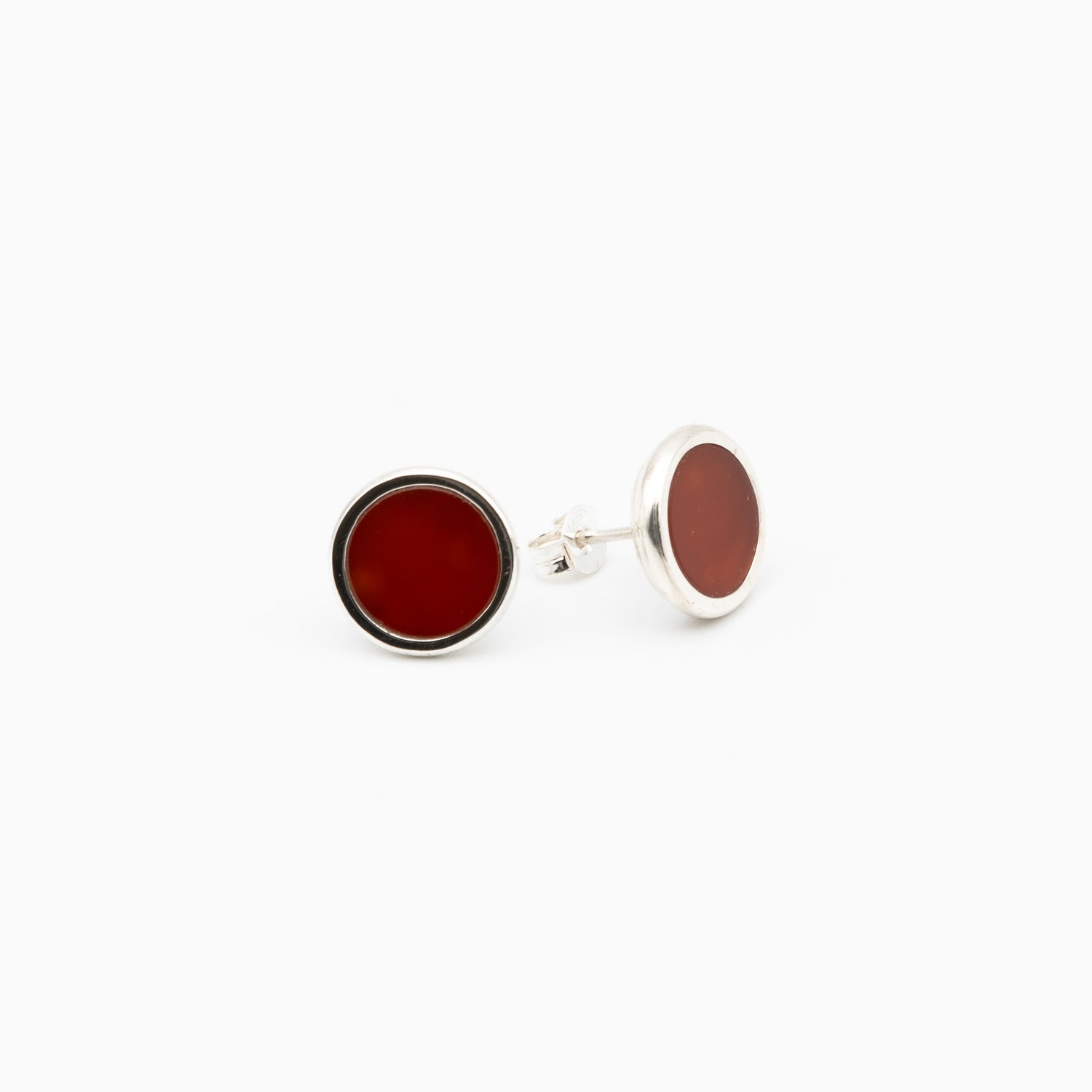 Round cufflinks with red stone on a white background