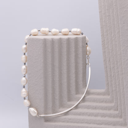 Pearl necklace  on a textured surface with a light gray background