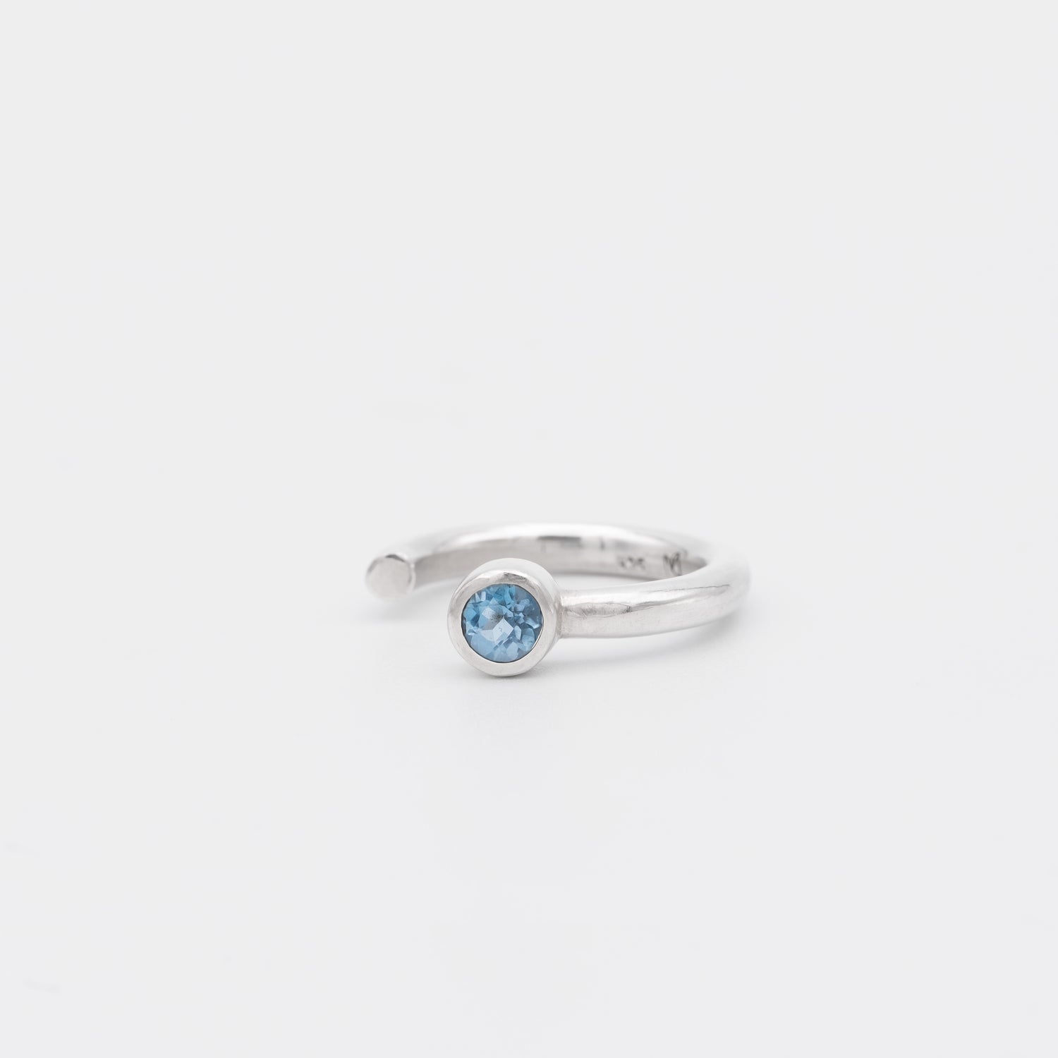Silver ring with a blue gemstone on a white background