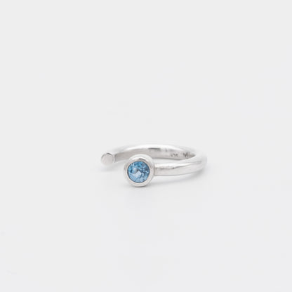 Silver ring with a blue gemstone on a white background
