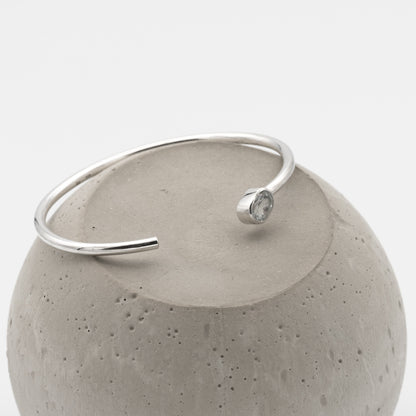 Silver bracelet with a gemstone on a concrete block