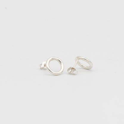 Pair of silver circle earrings on a light gray background