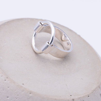 Silver ring on a textured beige surface