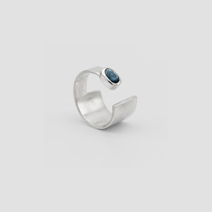 Silver ring with a blue gemstone on a light gray background london blue topaz
