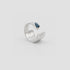 Silver ring with a blue gemstone on a light gray background london blue topaz