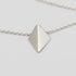Silver necklace with a pyramid-shaped pendant on a light gray background