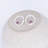Silver earrings with purple gemstones on a white stone tourmaline