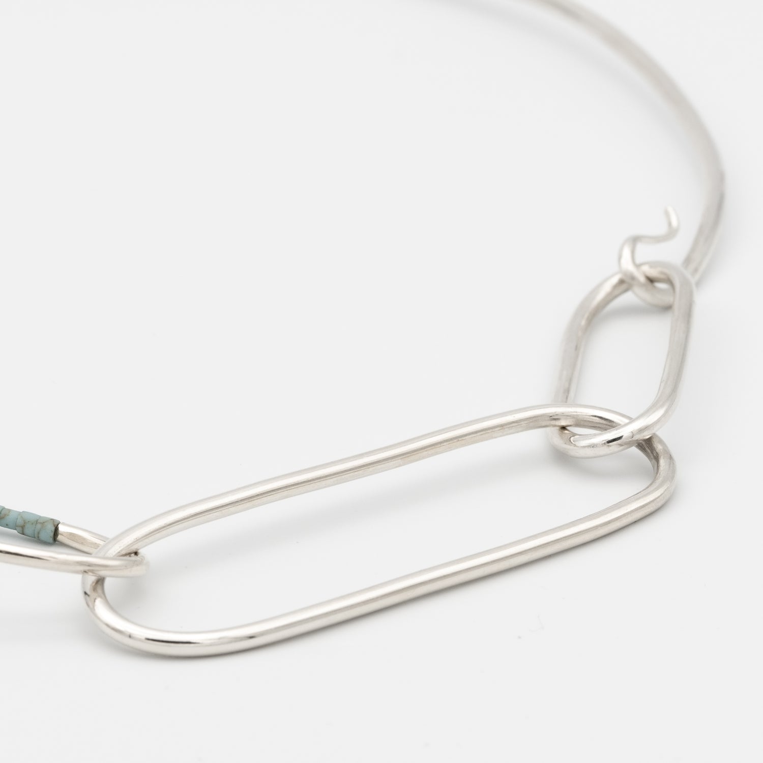 Silver chain necklace on a light gray background