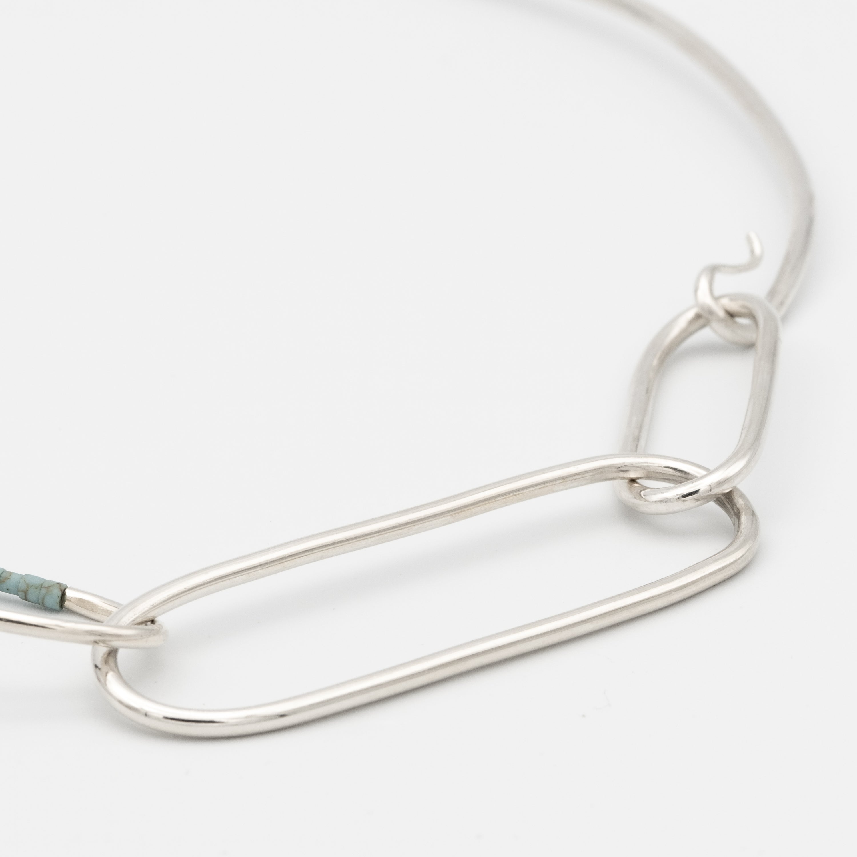 Silver chain necklace on a light gray background