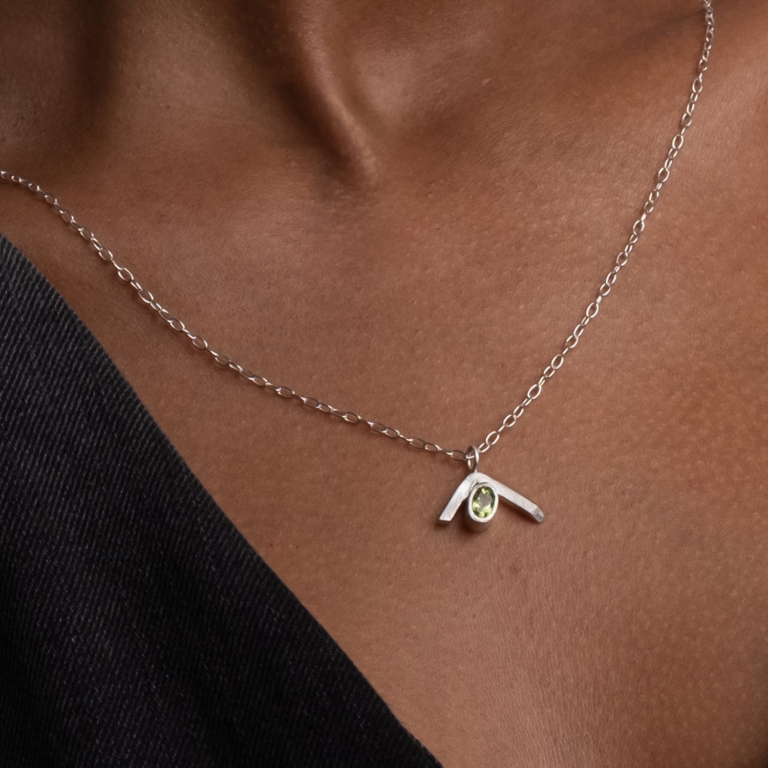 Necklace with a pendant featuring a yellow gemstone on a person&