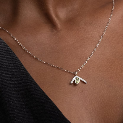Necklace with a pendant featuring a yellow gemstone on a person&