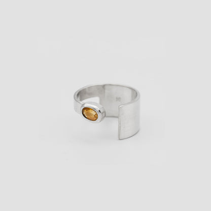 Silver ring with a small gemstone on a light gray background