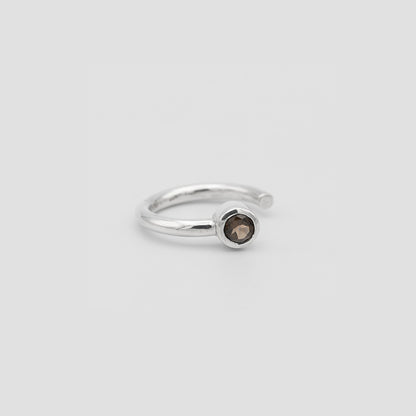 Silver ring with a brown gemstone on a light gray background