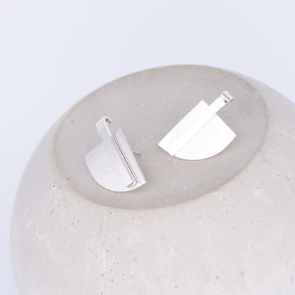 Silver earrings on a textured white surface