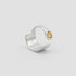 Silver ring with a yellow gemstone on a light gray background