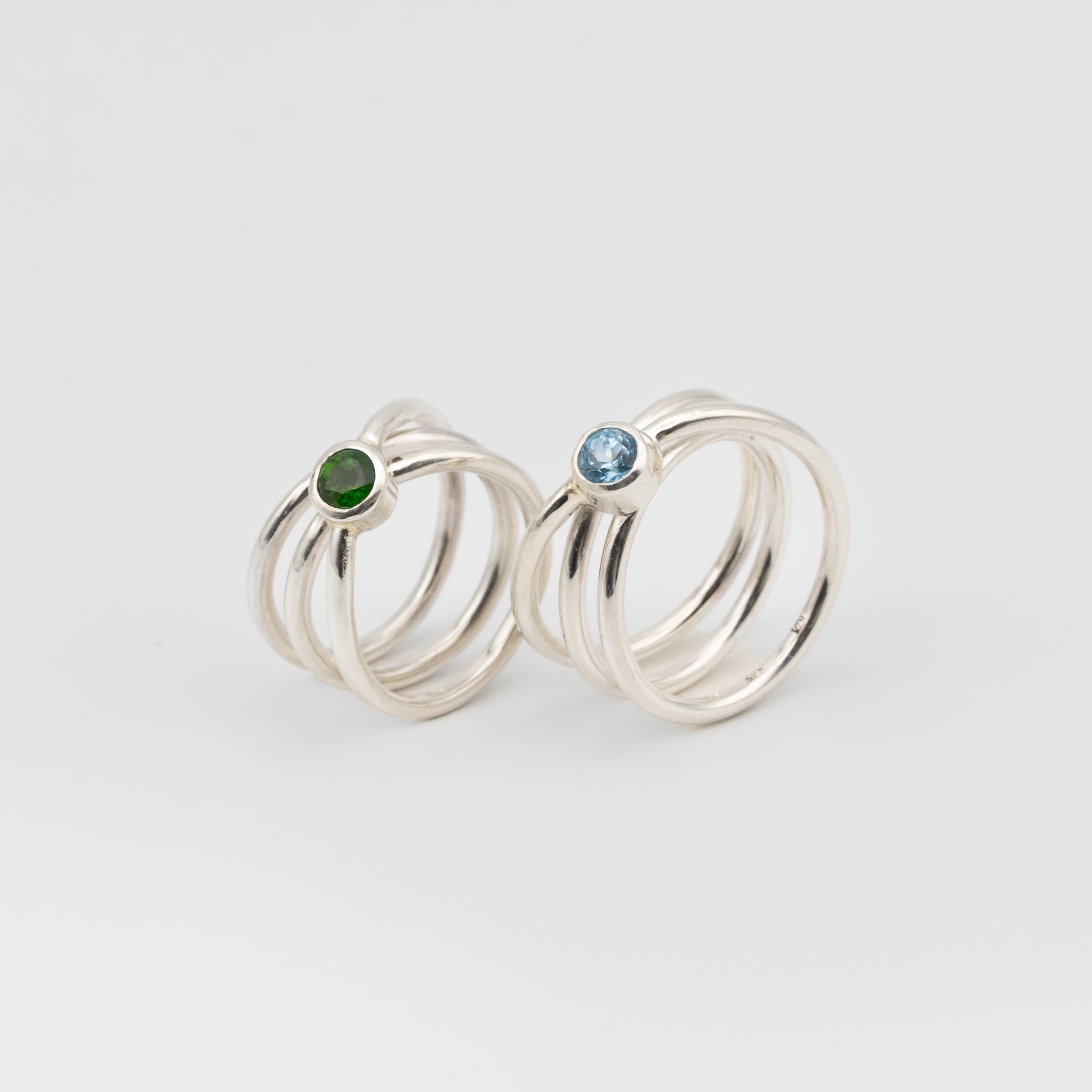 silver handmade rings in a shape of an orbit with a single gemstone set. now single silver wire wrapped and creating coils. 