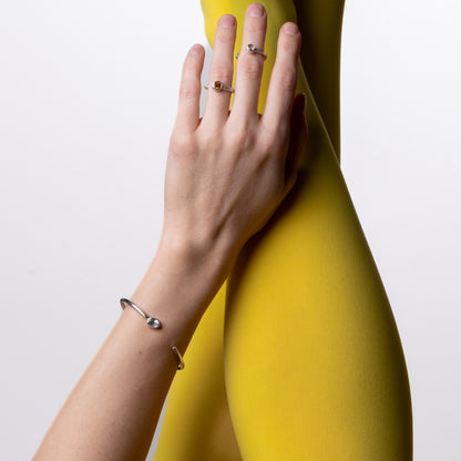 Person wearing yellow leggings with a hand on a white background